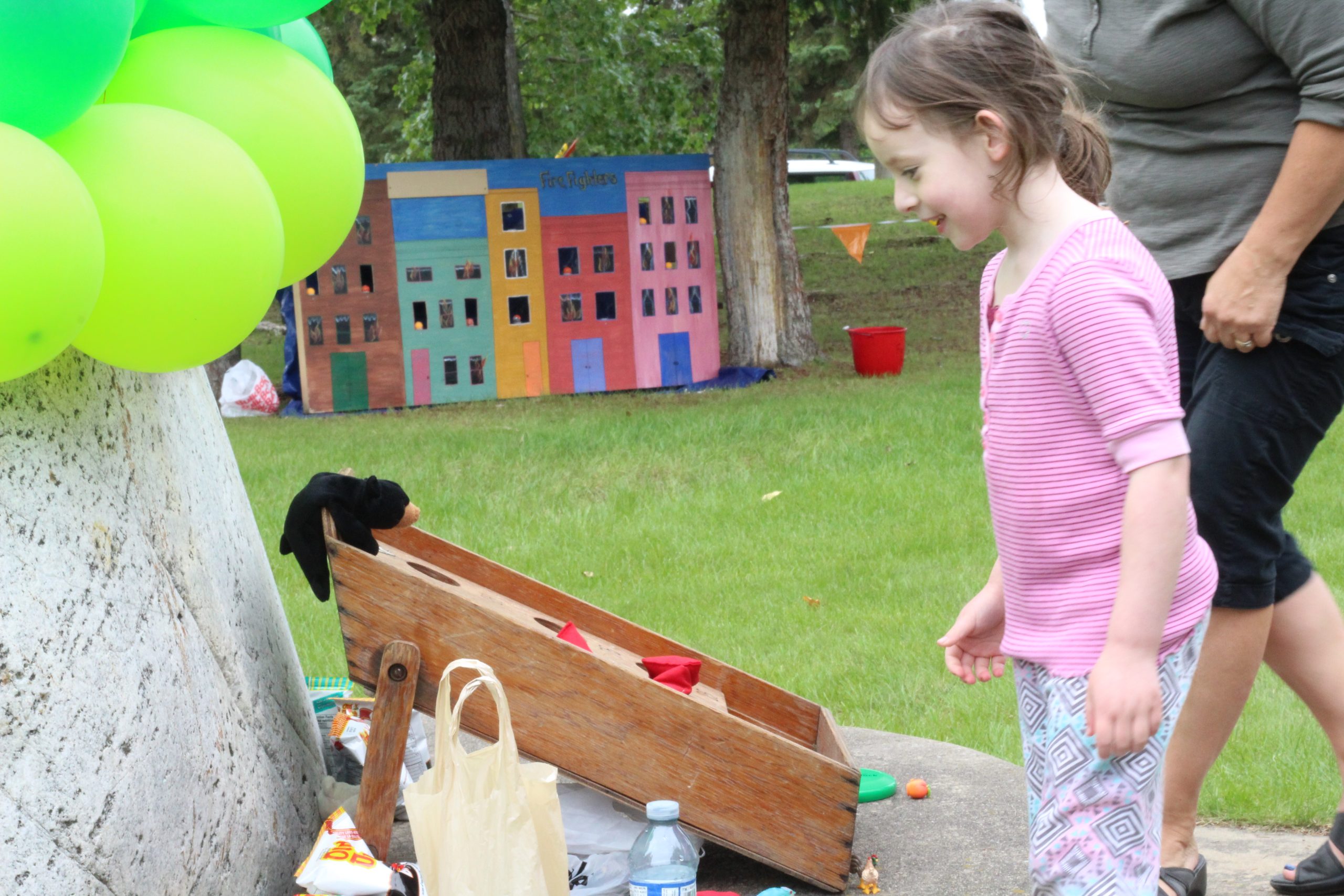 Young girl playing cornhole at a carnival day at Westlock Pioneer Museum