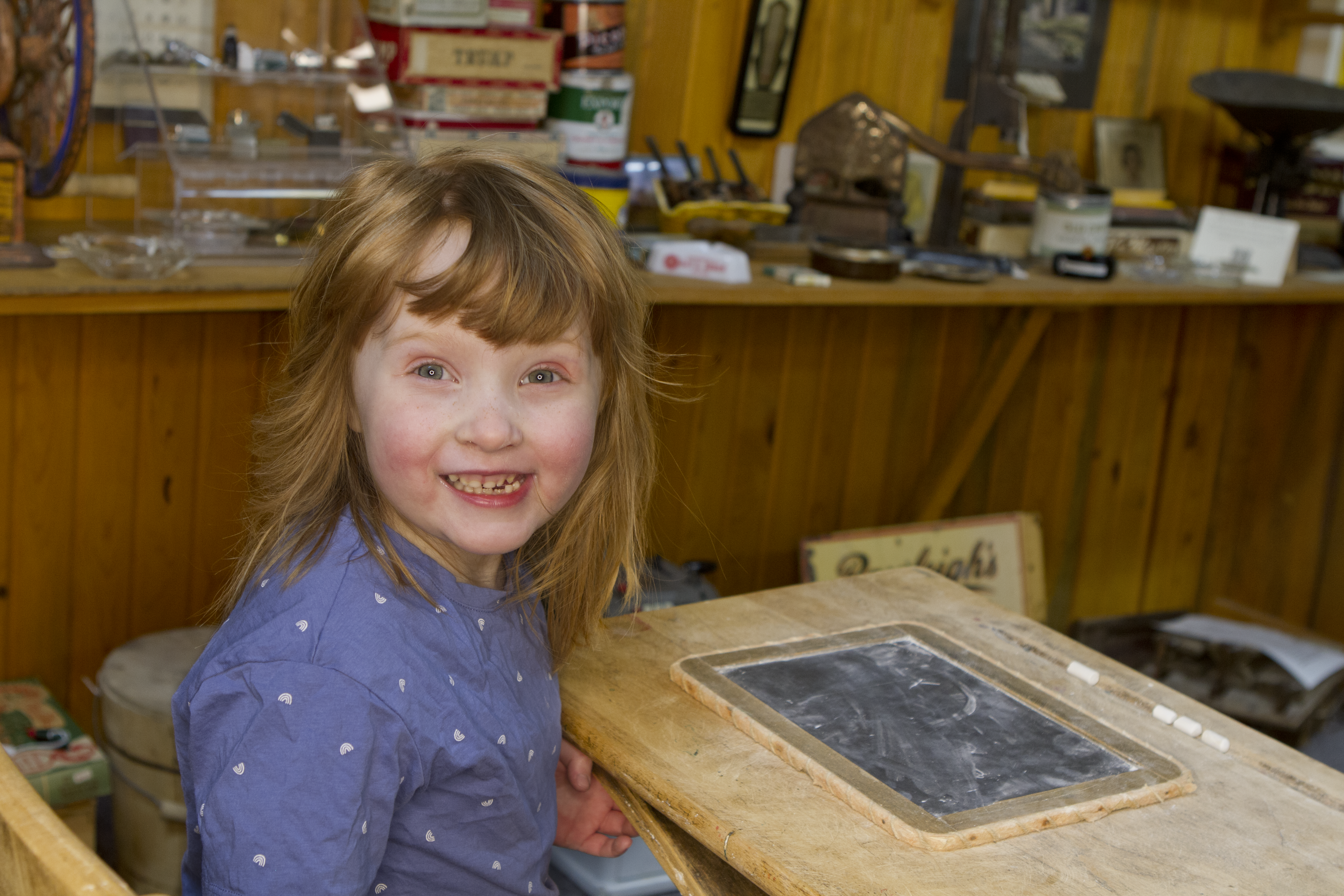 Young Girl Smiling at a Desk in the Museum